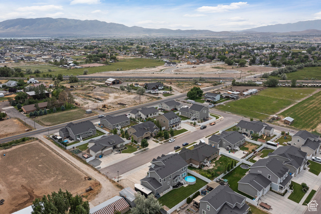Aerial view of property and surrounding area featuring a mountain backdrop and nearby suburban area