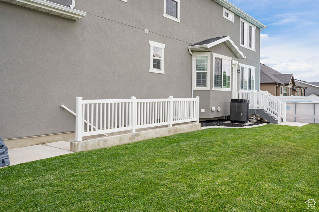 View of side of home with cooling unit and stucco siding