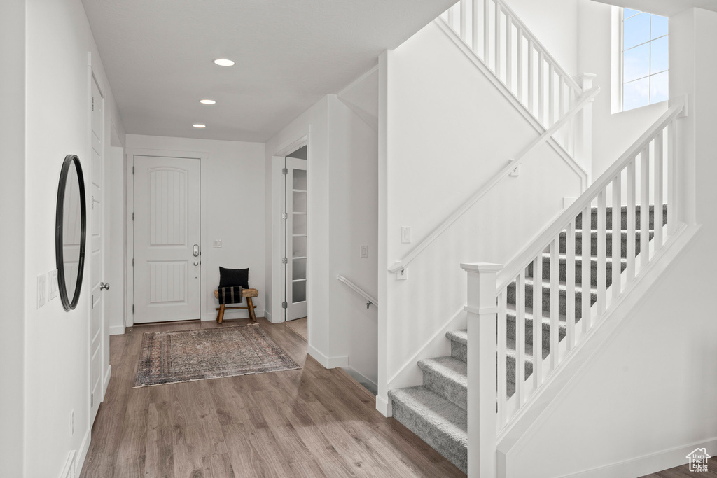Foyer featuring recessed lighting, wood finished floors, baseboards, and stairway