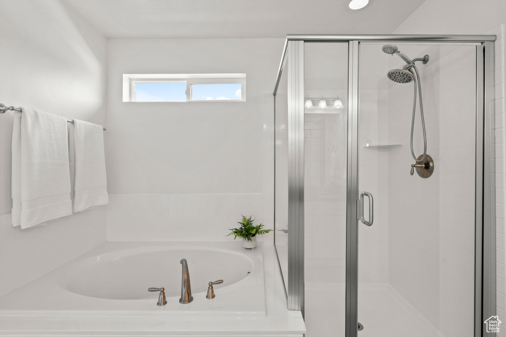 Bathroom with a shower stall and a bath