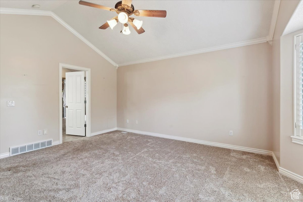 Unfurnished room with ceiling fan, carpet, lofted ceiling, baseboards, and crown molding
