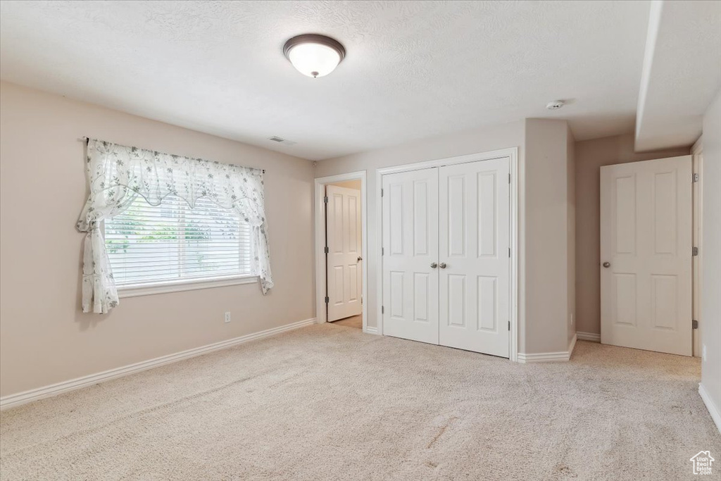 Unfurnished bedroom featuring carpet, a closet, and baseboards