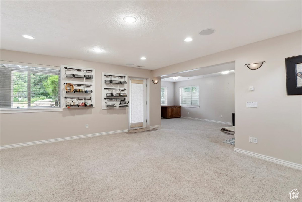 Unfurnished living room featuring carpet flooring, recessed lighting, and baseboards