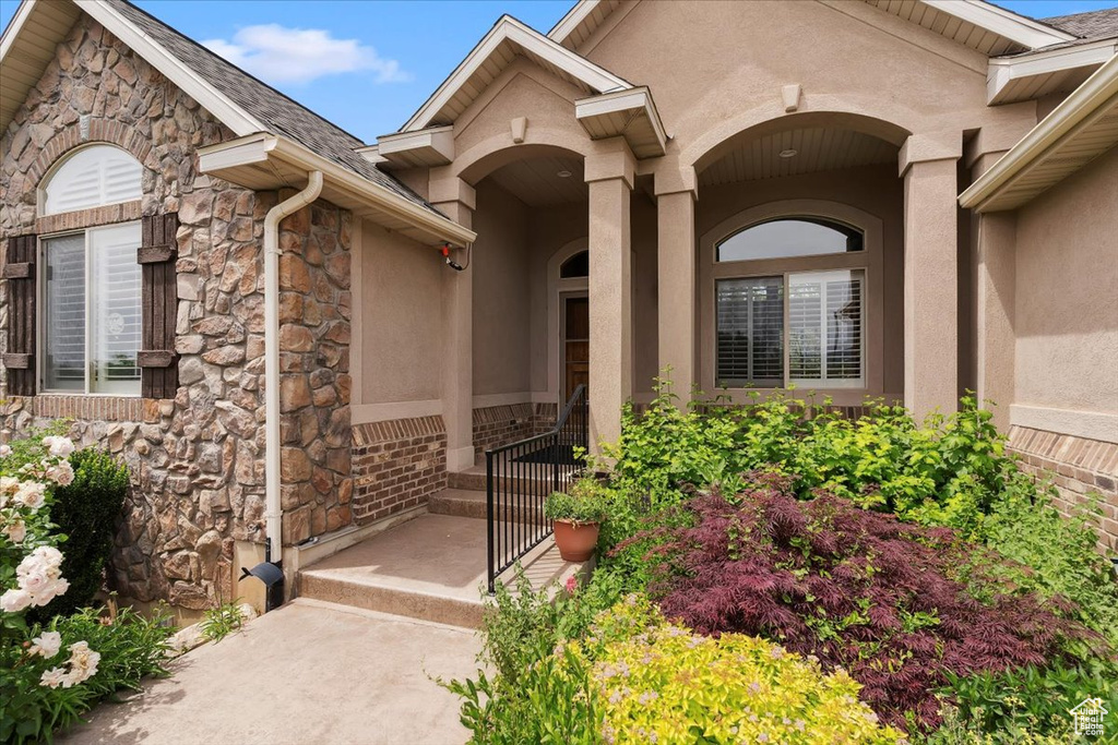 Doorway to property with stone siding and stucco siding