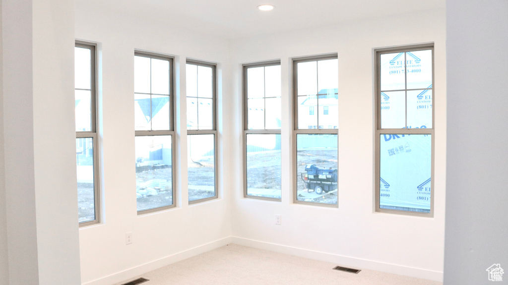 Empty room with light colored carpet, baseboards, and recessed lighting