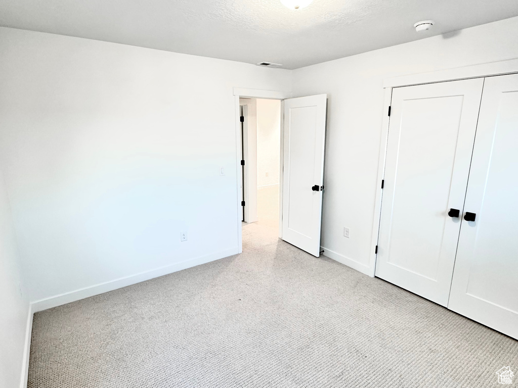 Unfurnished bedroom with baseboards, a closet, and carpet floors