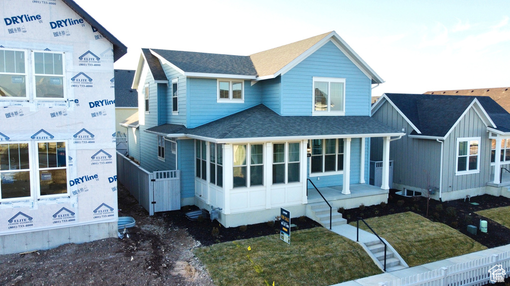 View of front of property with roof with shingles and covered porch