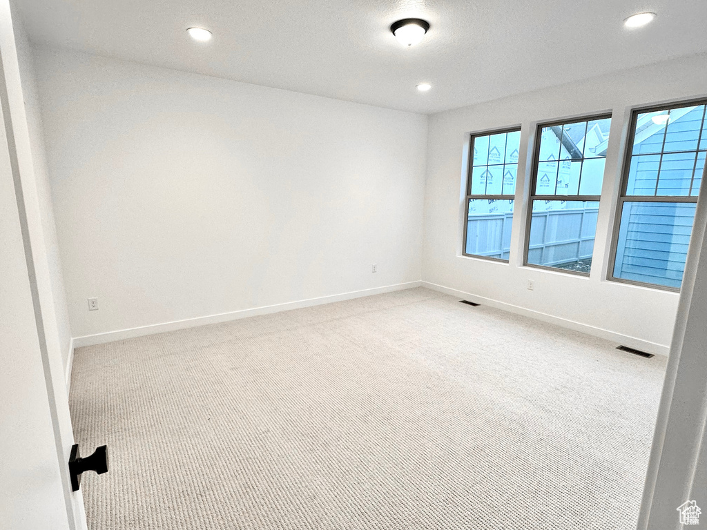 Carpeted empty room with baseboards and recessed lighting