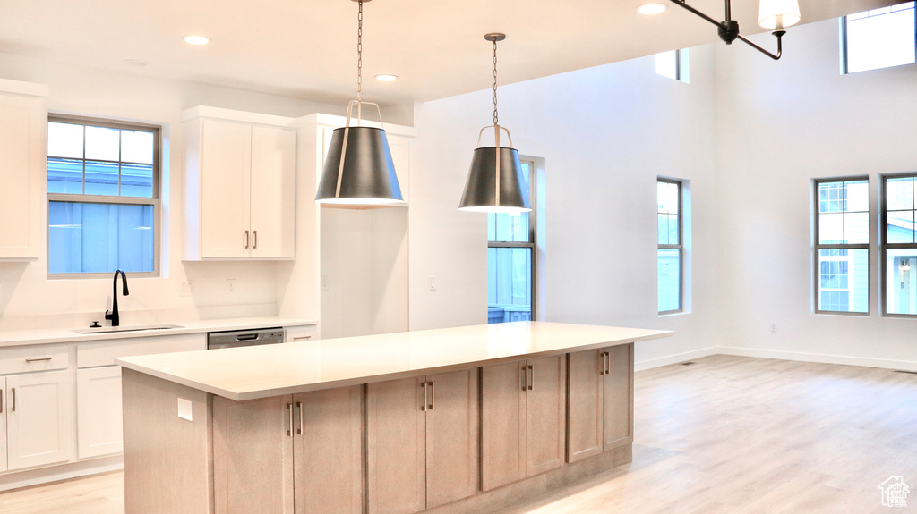 Kitchen featuring a sink, a kitchen island, plenty of natural light, and recessed lighting