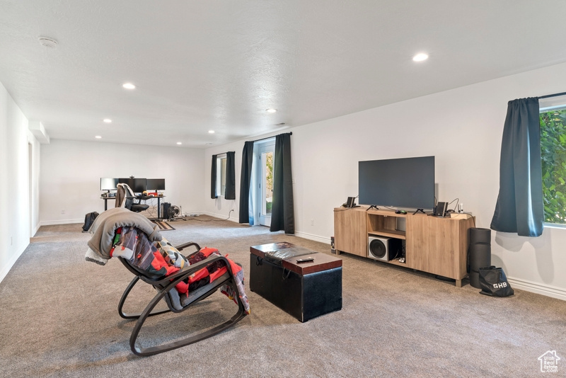 Living room with light carpet, recessed lighting, an office area, baseboards, and healthy amount of natural light