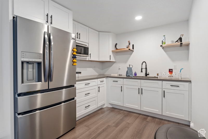 Kitchen featuring stainless steel appliances, open shelves, a sink, white cabinetry, and recessed lighting