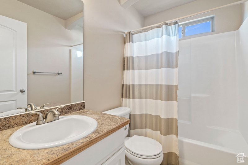 Full bathroom with vanity, toilet, and shower / bathtub combination with curtain