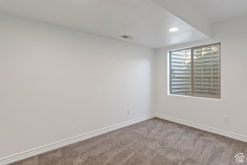 Carpeted empty room with baseboards and recessed lighting
