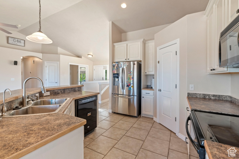 Kitchen featuring black appliances, a sink, white cabinets, pendant lighting, and lofted ceiling