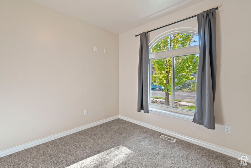 Empty room with carpet floors and baseboards