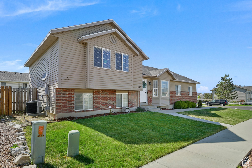 Split level home featuring brick siding and cooling unit