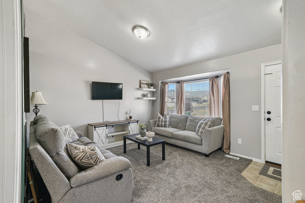 Living room featuring vaulted ceiling and light colored carpet