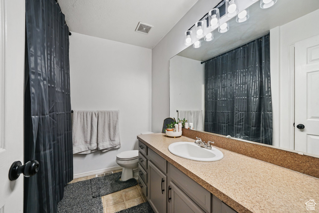 Full bathroom featuring vanity, toilet, baseboards, tile patterned flooring, and a shower with curtain