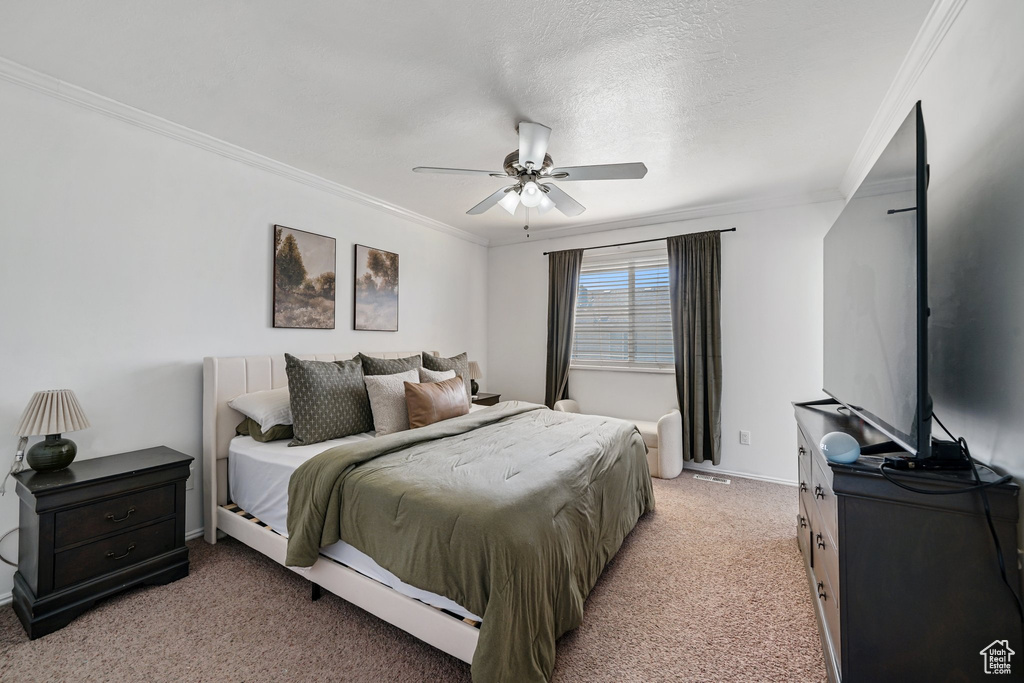Bedroom with light carpet, crown molding, baseboards, and a ceiling fan