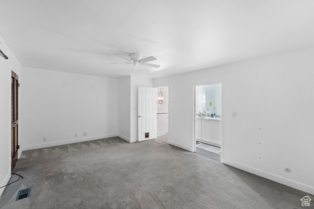Unfurnished bedroom with carpet floors, baseboards, ensuite bathroom, and a ceiling fan