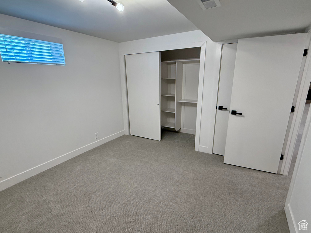 Unfurnished bedroom with carpet floors, baseboards, and a closet