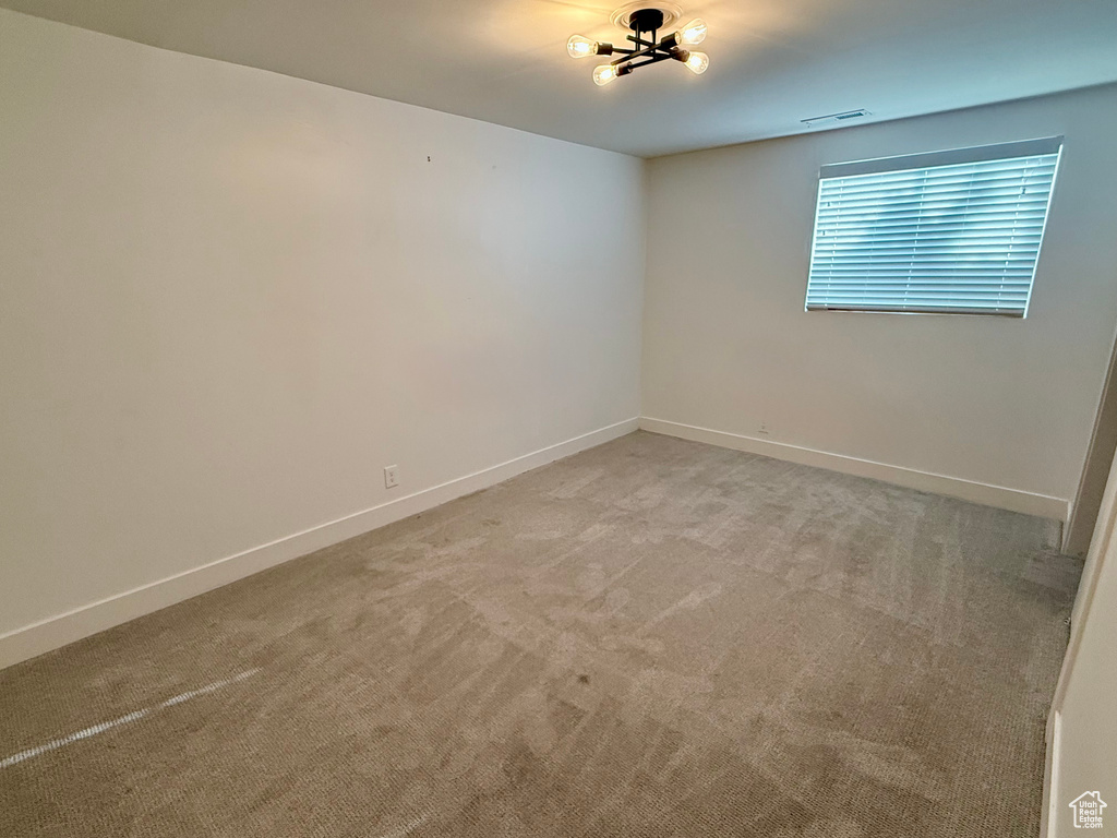 Unfurnished room featuring light carpet and baseboards