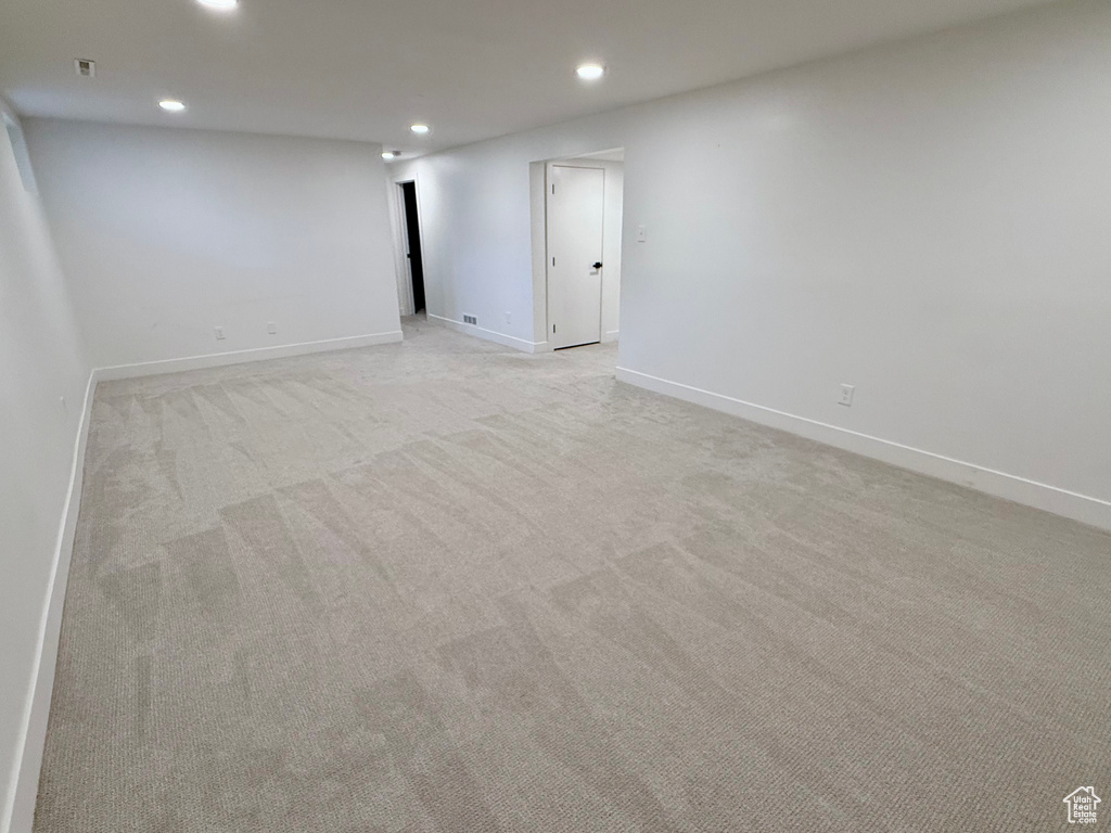 Spare room with recessed lighting, light colored carpet, and baseboards