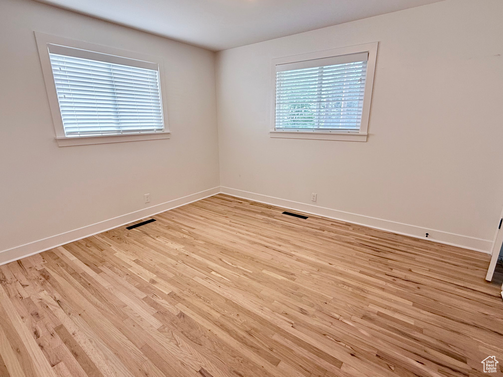 Empty room with light wood finished floors and baseboards