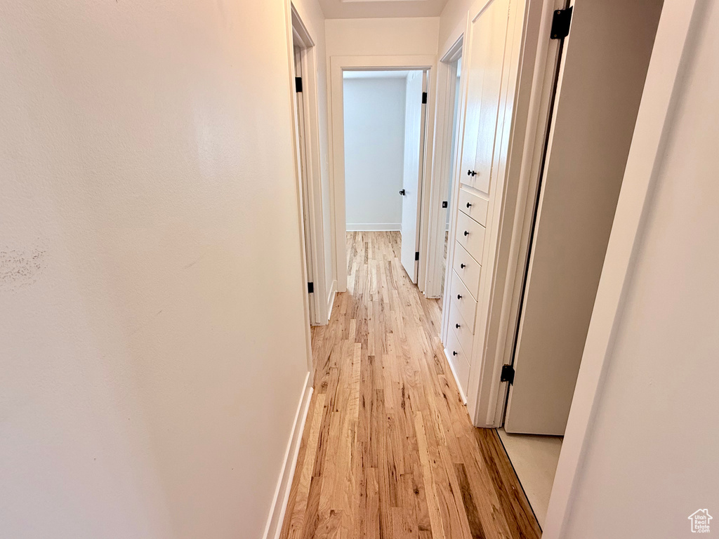 Hall featuring light wood-style flooring and baseboards