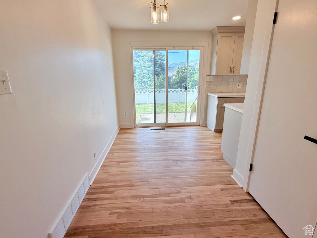 Unfurnished dining area with light wood finished floors, baseboards, and recessed lighting
