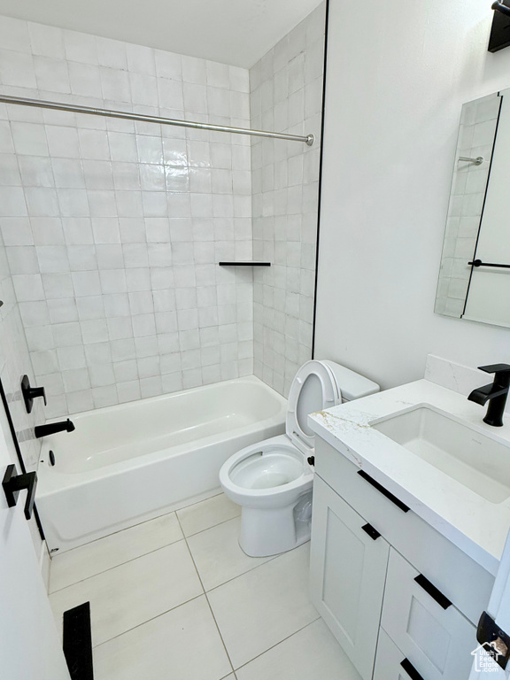 Bathroom with tile patterned floors, vanity, toilet, and  shower combination
