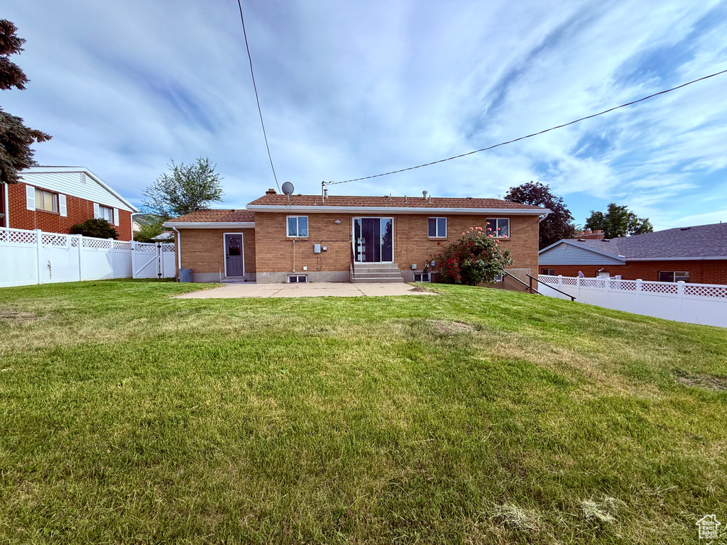 Rear view of house featuring entry steps, a patio, and brick siding