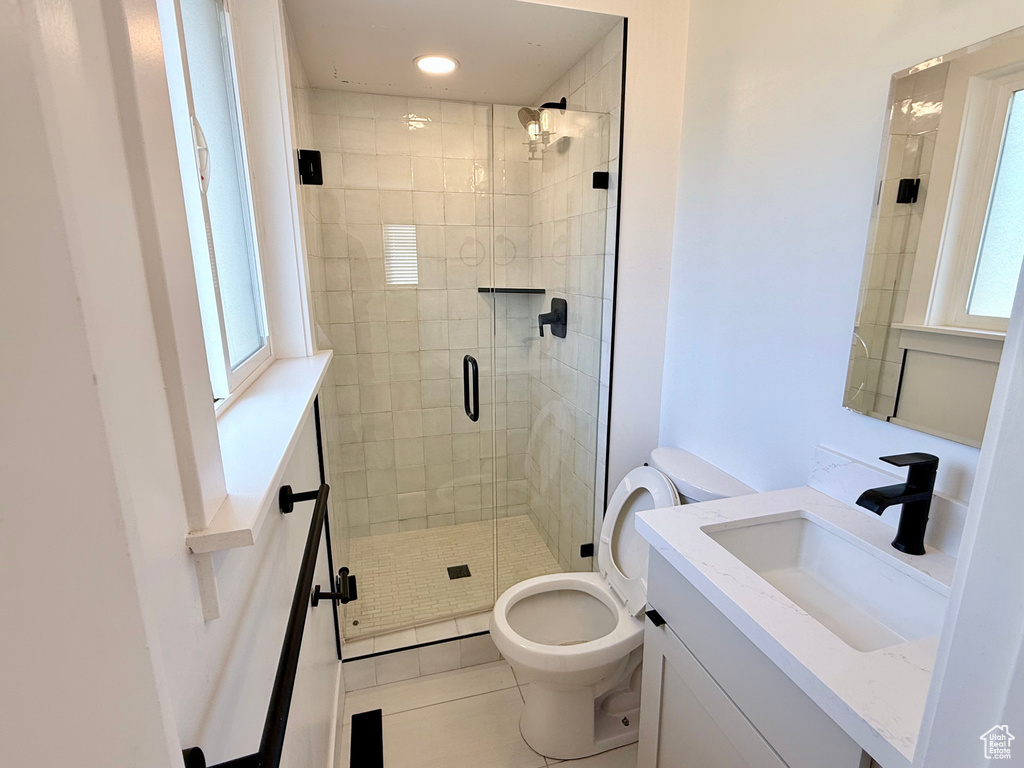 Bathroom featuring toilet, vanity, a stall shower, tile patterned floors, and recessed lighting