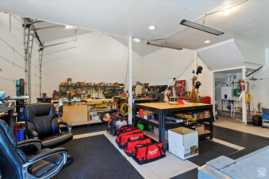 Garage featuring a workshop area, recessed lighting, and tankless water heater