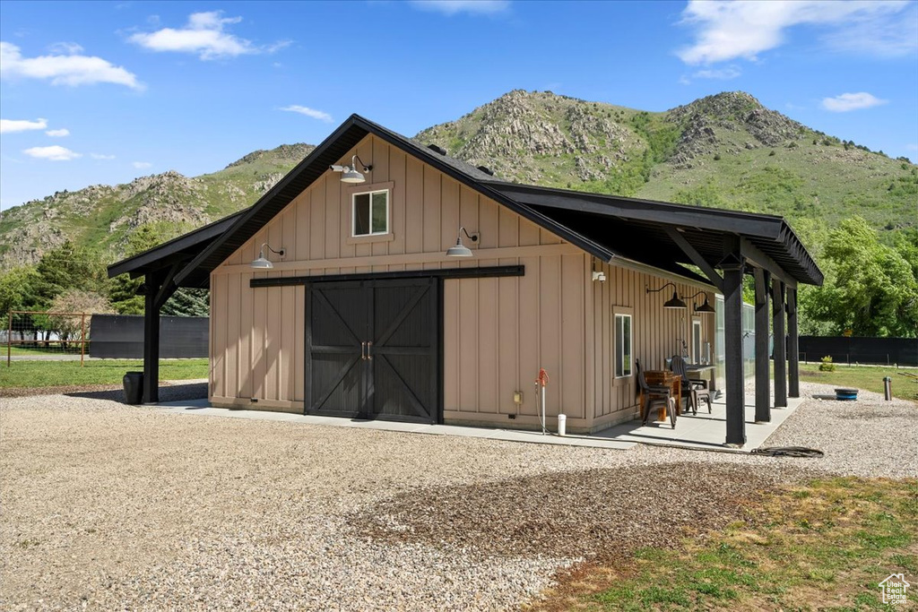 View of outdoor structure featuring a mountain view, an outbuilding, and fence