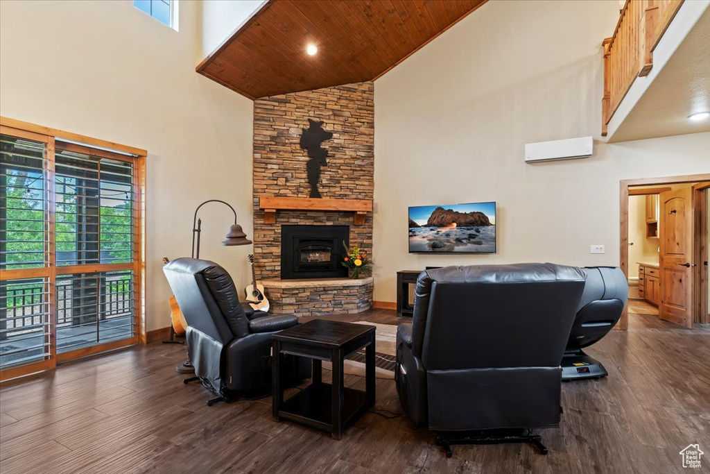 Living room with high vaulted ceiling, dark wood-style flooring, plenty of natural light, wood ceiling, and a stone fireplace