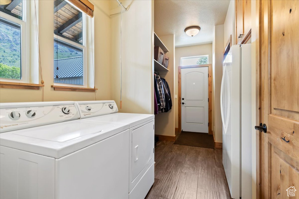 Washroom featuring independent washer and dryer, dark wood-style floors, and baseboards
