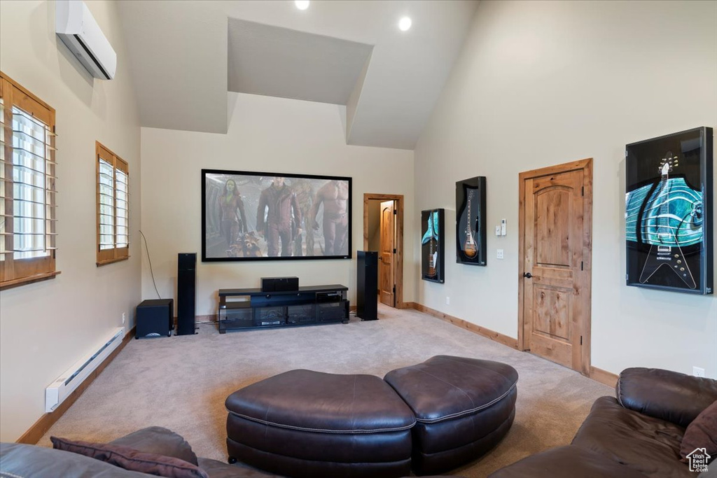 Cinema with a baseboard heating unit, a wall mounted air conditioner, carpet flooring, baseboards, and high vaulted ceiling