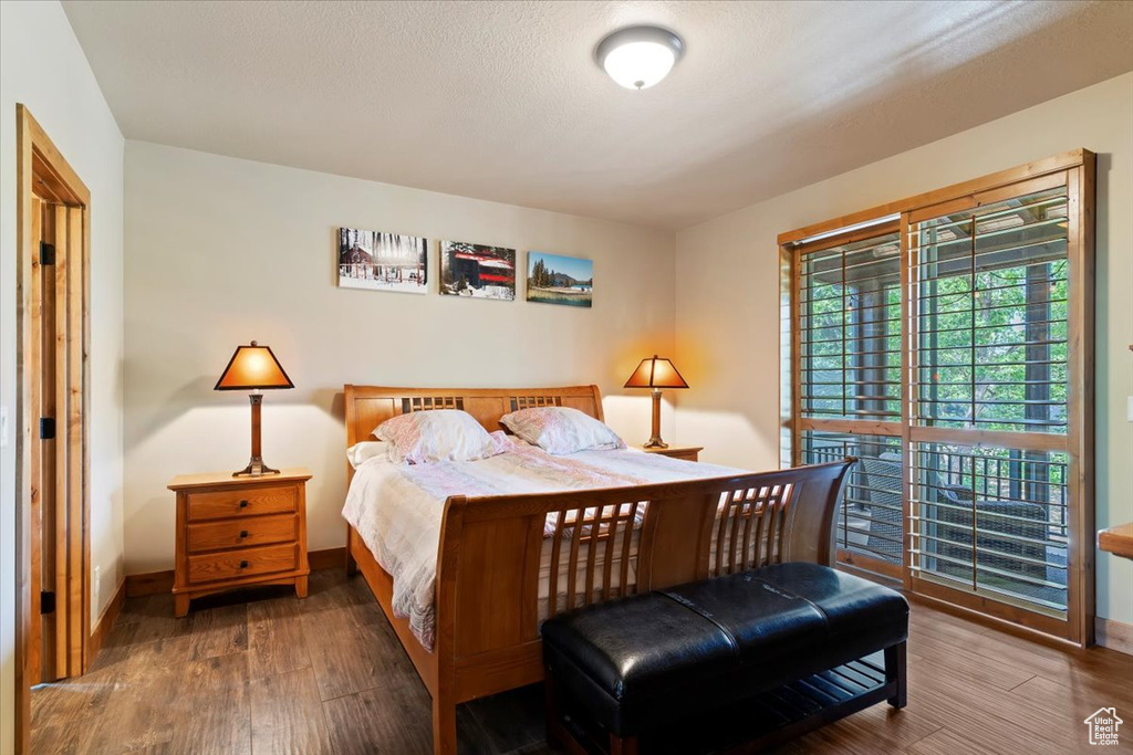 Bedroom with wood finished floors and baseboards