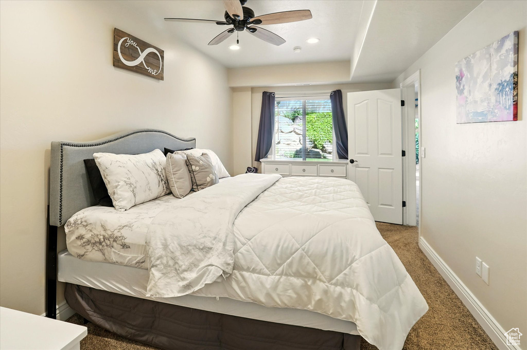 Carpeted bedroom with baseboards and a ceiling fan