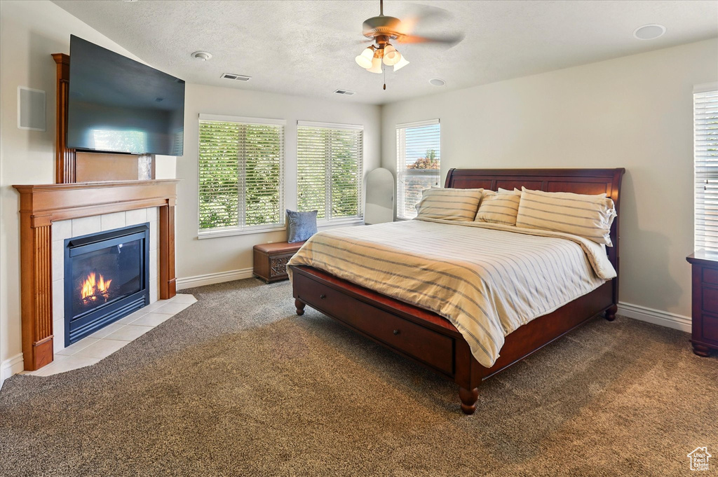Bedroom with carpet, a tile fireplace, and baseboards