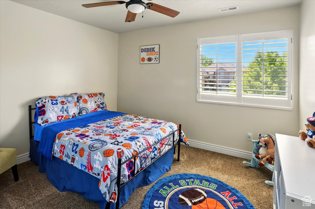 Bedroom with carpet, a ceiling fan, and baseboards