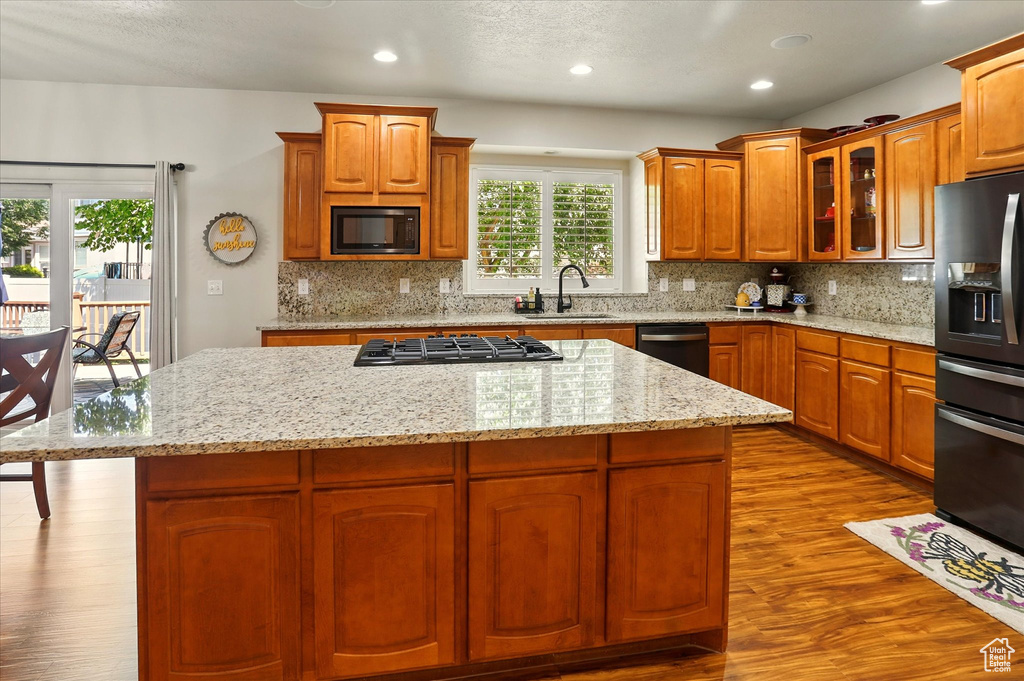 Kitchen featuring stainless steel appliances, a sink, a kitchen island, dark wood-style flooring, and recessed lighting