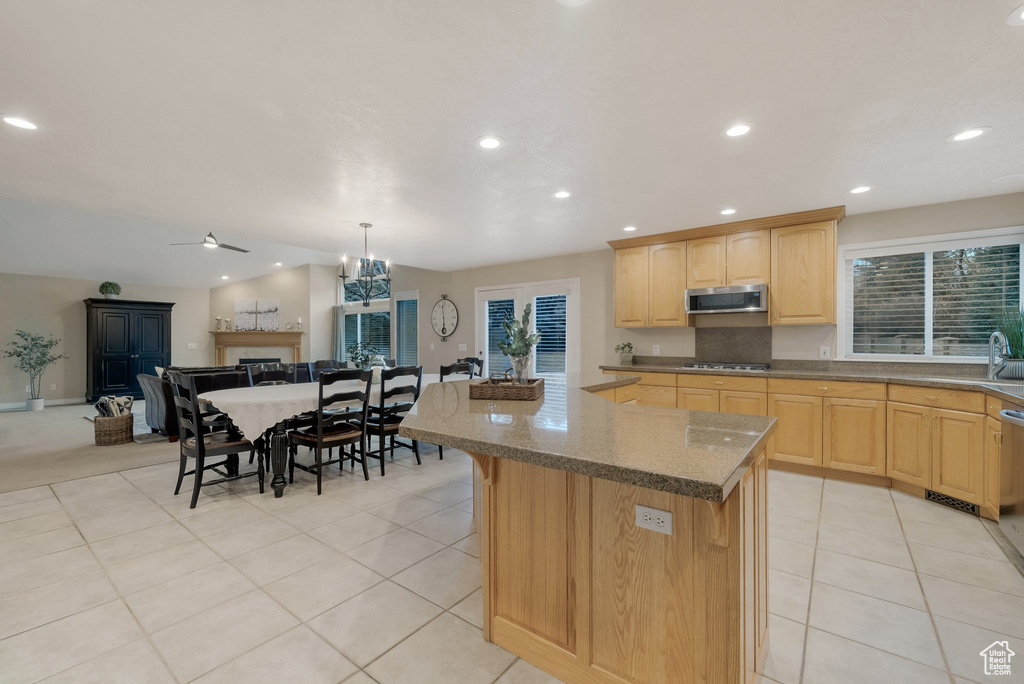 Kitchen with appliances with stainless steel finishes, open floor plan, light brown cabinetry, recessed lighting, and dark stone counters