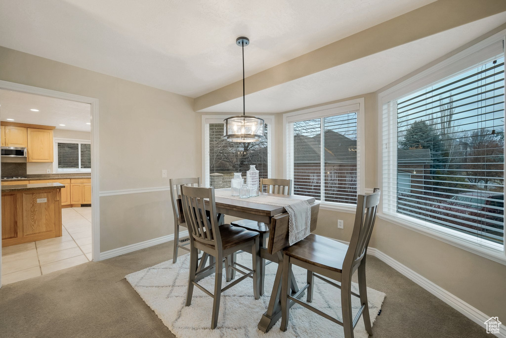 Dining space with light carpet, baseboards, and light tile patterned floors