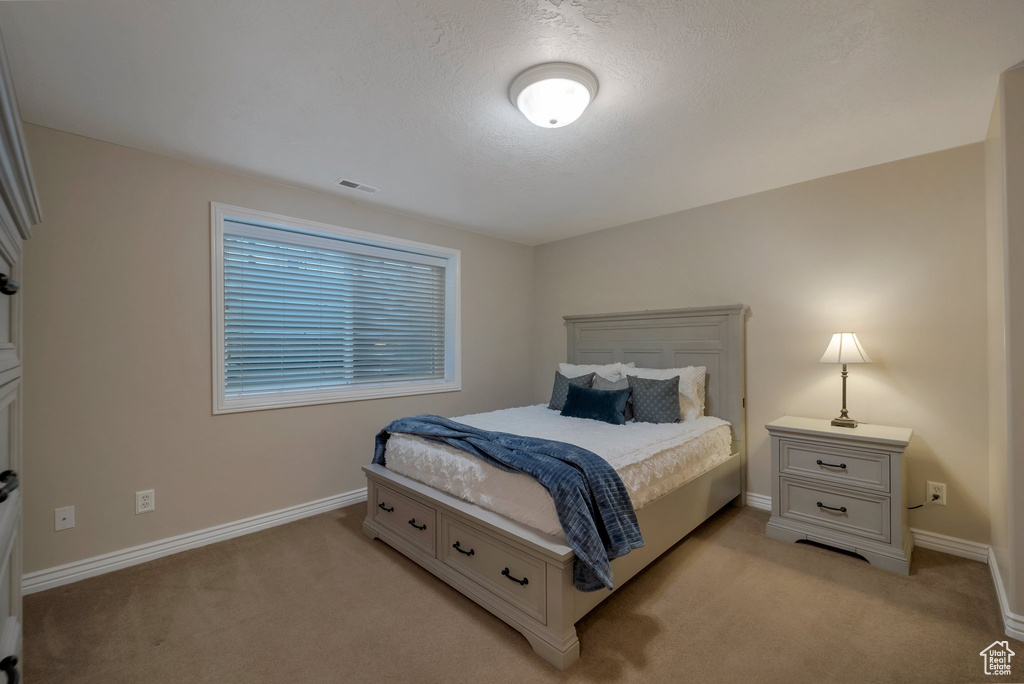 Bedroom featuring light colored carpet and baseboards