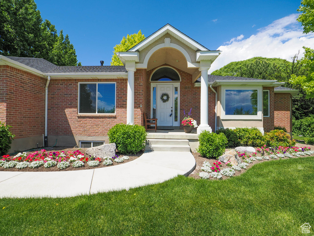 View of front facade featuring brick siding and a front lawn