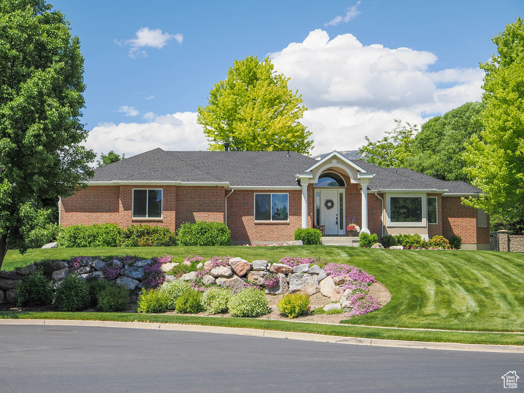 Ranch-style home featuring a front yard and brick siding