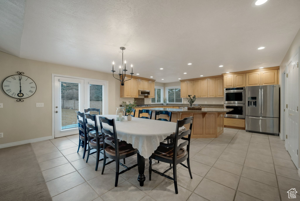Dining area with recessed lighting, baseboards, a chandelier, and light tile patterned floors