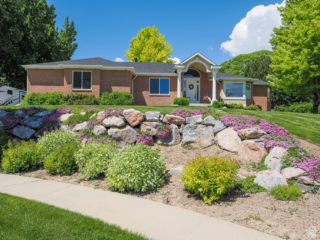 Single story home featuring brick siding and a front lawn